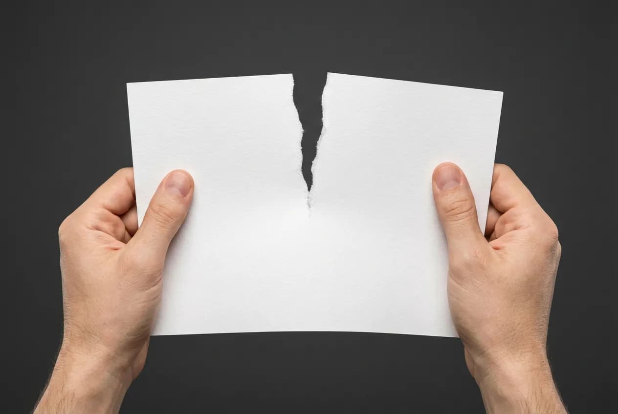 Eurodatacar Résilier : Guide Simple pour Annuler Votre Contrat Une main déchire un contrat en deux, icône minimaliste pour la résiliation d'Eurodatacar.